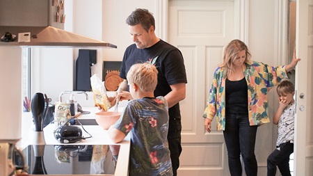Familie baker på kjøkkenet