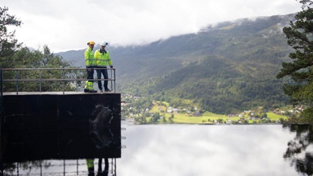 To menn fra Kvam Energi ser ut over demning