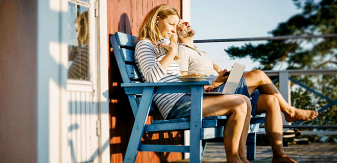 Par som sitter på veranda med kaffe