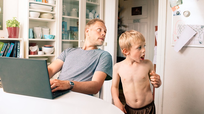 man working on laptop next to boy