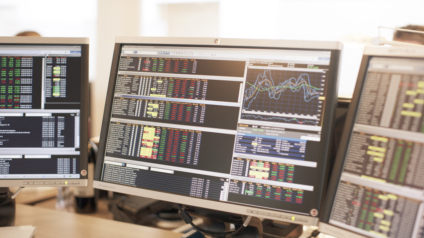 illustrasjonsbilde av tre dataskjermer som viser aksjeutvikling